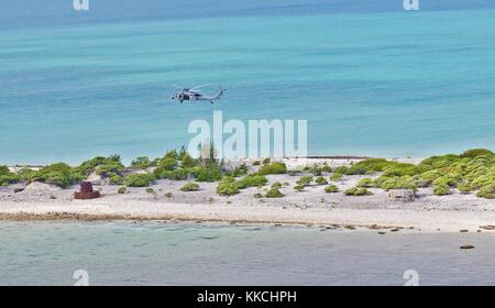 An MH-60S Sea Hawk helicopter assigned to the Blackjacks of Helicopter Sea Combat Squadron HSC 21 flies over Wake Island during practice flight operations, Wake Island. Image courtesy Mass Communication Specialist 3rd Class Michael Feddersen/US Navy. 2012. Stock Photo