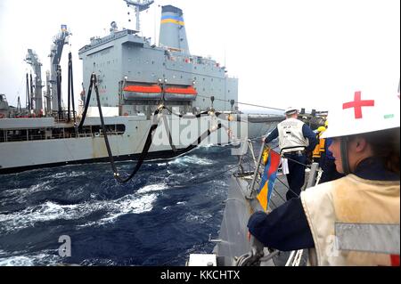 Hospital Corpsman 3rd Class Melissa Lusk, assigned to the Arleigh Burke-class guided-missile destroyer USS McCampbell DDG 85, looks on as a refueling probe pumps fuel into the ship during a replenishment at sea with the Military Sealift Command Henry J Kaiser-class fleet replenishment oiler USNS Walter S Diehl T-AO 193, East China Sea, 2012. Image courtesy Mass Communication Specialist Seaman Declan Barnes/US Navy. Stock Photo