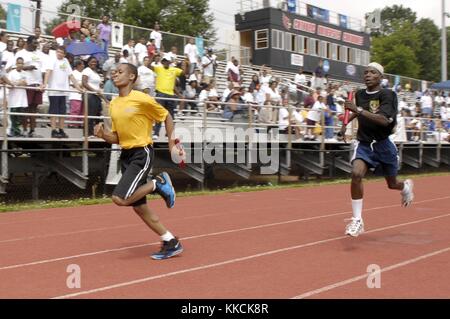 Runners at the 2012 Washington DC Special Olympics represent the US Navy and Army during a 4x100 meter relay race at the 2012 Washington DC Special Olympics, Washington. Image courtesy U.S. Air Force photo by Sr. Airman Steele C. G. Britton/US Navy, 2012. Stock Photo