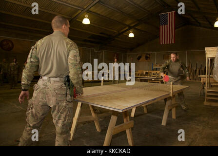 U.S. Army Gen. Robert Abrams, commanding general of U.S. Army Forces Command, plays ping pong with Command Sgt. Maj. Michael Grinston while visiting Soldiers deployed in support of Combined Joint Task Force – Operation Inherent Resolve and assigned to the 458th Engineer Battalion at Camp Taji, Iraq, Nov. 16, 2017. Camp Taji is one of four CJTF-OIR building partner capacity locations dedicated to training partner forces and enhancing their effectiveness on the battlefield. CJTF-OIR is the global Coalition to defeat ISIS in Iraq and Syria. (U.S. Army photo by Cpl. Rachel Diehm) Stock Photo