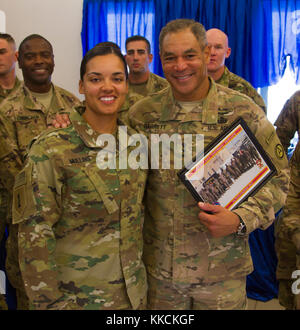 Soldiers from the 11th Air Defense Artillery Brigade and 2nd Battalion, 43rd Air Defense Artillery Regiment present Lt. Gen. Michael Garrett, Commanding General of U.S. Army Central, with a unit photo as a gift following his visit to Al Udeid Air Base in Qatar on Nov. 18. The intent of Garrett’s visit to AUAB was to discuss the mission, tasks, and purpose with Soldiers and officers stationed at the base. (U.S. photo taken by Spc. Joshua P. Morris, U.S. ARCENT PAO) Stock Photo