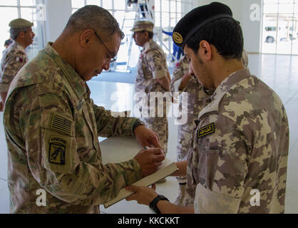 Lt. Gen. Michael Garrett, Commanding General of U.S. Army Central, signs a book reserved for distinguished guests of the Qatar Armed Forces at a base located in Qatar on Nov. 19. Garrett traveled to Qatar to further strengthen the partnership ties with the allied military, which is also in the USARCENT area of responsibility. (U.S. photo taken by Spc. Joshua P. Morris, U.S. ARCENT PAO) Stock Photo