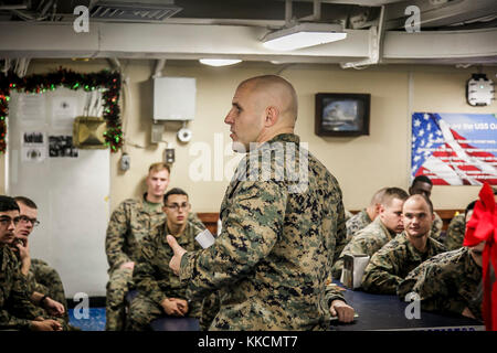 U.S. Marine Corps 1st Sgt. Christian Appleman, first sergeant of Fox Company, 2nd Battalion, 6th Marine Regiment, 26th Marine Expeditionary Unit (MEU), and senior enlisted advisor aboard the dock landing ship USS Oak Hill (LSD 51), leads a guided discussion as the culminating event of a Lance Corporal Seminar aboard the Oak Hill, during Combined Composite Training Unit Exercise (COMPTUEX) in the Atlantic Ocean Nov. 25, 2017. Combined COMPTUEX serves as the capstone event for the Amphibious Ready Group-MEU team prior to a deployment, fully integrating the ARG-MEU team as an amphibious force and Stock Photo