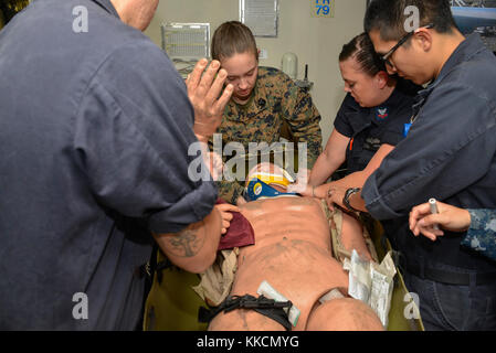 ATLANTIC OCEAN (Nov. 25, 2017) A medical team assigned to the amphibious assault ship USS Iwo Jima treats simulated wounds on a practice dummy in the ship’s medical ward. Iwo Jima, components of the Iwo Jima Amphibious Ready Group and the 26th Marine Expeditionary Unit are conducting a Combined Composite Training Unit Exercise that is the culmination of training for the Navy-Marine Corps team and will certify them for deployment. (U.S. Navy photo by Mass Communication Specialist 3rd Class Kevin Leitner/Released) Stock Photo