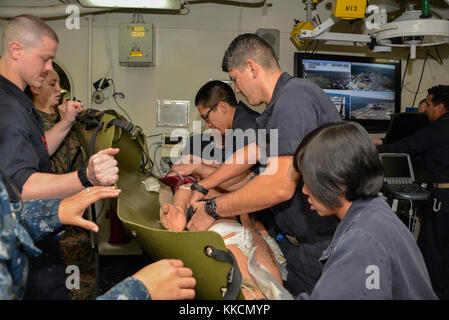 ATLANTIC OCEAN (Nov. 25, 2017) A medical team assigned to the amphibious assault ship USS Iwo Jima treats simulated wounds on a practice dummy in the ship’s medical ward. Iwo Jima, components of the Iwo Jima Amphibious Ready Group and the 26th Marine Expeditionary Unit are conducting a Combined Composite Training Unit Exercise that is the culmination of training for the Navy-Marine Corps team and will certify them for deployment. (U.S. Navy photo by Mass Communication Specialist 3rd Class Kevin Leitner/Released) Stock Photo