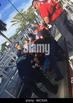 A 45-foot Response Boat-Medium boatcrew from Coast Guard Station Fort Myers Beach medevacs a 26-year-old man from a 27-foot dive boat, Reel Cowboy, 31 miles west of Naples, Florida, Sunday, Nov. 26, 2017. The Coast Guard, in partnership with Fort Myers Beach Fire rescue, transported the man to shore where an ambulance awaited.(U.S. Coast Guard photo) Stock Photo