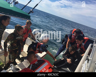 A 45-foot Response Boat-Medium boatcrew from Coast Guard Station Fort Myers Beach medevacs a 26-year-old man from a 27-foot dive boat, Reel Cowboy, 31 miles west of Naples, Florida, Sunday, Nov. 26, 2017. The Coast Guard, in partnership with Fort Myers Beach Fire rescue, transported the man to shore where an ambulance awaited.(U.S. Coast Guard photo) Stock Photo