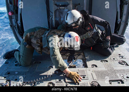 ATLANTIC OCEAN (Nov. 26, 2017) Hospital Corpsman 2nd Class Erin Williams, left, and Naval Air Crewman (Helicopter) 3rd Class Austin Rivera, both assigned to Helicopter Sea Combat Squadron 28, assist Sailors from the fleet replenishment oiler USNS Big Horn (T-AO 198) in attaching a pallet to the cargo hook of an MH-60S Sea Hawk during a replenishment-at-sea. The amphibious assault ship USS Iwo Jima (LHD 7), components of the Iwo Jima Amphibious Ready Group and the 26th Marine Expeditionary Unit are conducting a Combined Composite Training Unit Exercise that is the culmination of training for th