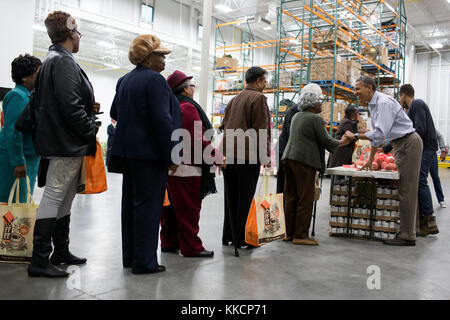 President Barack Obama talks with people as he and members of the Obama family participate in a service project at the Capital Area Food Bank in Washington, D.C., Nov. 21, 2012. (Official White House Photo by Pete Souza)  This official White House photograph is being made available only for publication by news organizations and/or for personal use printing by the subject(s) of the photograph. The photograph may not be manipulated in any way and may not be used in commercial or political materials, advertisements, emails, products, promotions that in any way suggests approval or endorsement of  Stock Photo