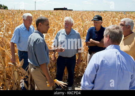 President Barack Obama talks with farmers during a tour of the McIntosh family farm to view the effects of the drought, in Missouri Valley, Iowa, Aug. 13, 2012. Secretary of Agriculture Tom Vilsack, foreground, joins the President. (Official White House Photo by Pete Souza)  This official White House photograph is being made available only for publication by news organizations and/or for personal use printing by the subject(s) of the photograph. The photograph may not be manipulated in any way and may not be used in commercial or political materials, advertisements, emails, products, promotion Stock Photo