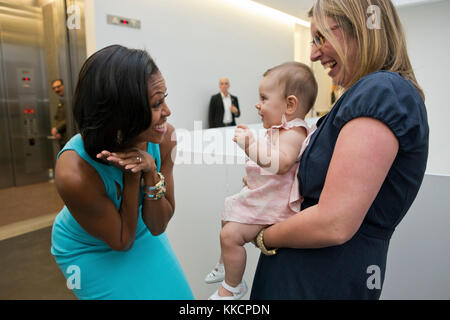 First Lady Michelle Obama greets former White House staffer Franny Starkey and her daughter Willa prior to an event at the Museum of Contemporary Art Denver in Denver, Colo., Aug. 11, 2012. (Official White House Photo by Sonya N. Hebert)  This official White House photograph is being made available only for publication by news organizations and/or for personal use printing by the subject(s) of the photograph. The photograph may not be manipulated in any way and may not be used in commercial or political materials, advertisements, emails, products, promotions that in any way suggests approval o Stock Photo