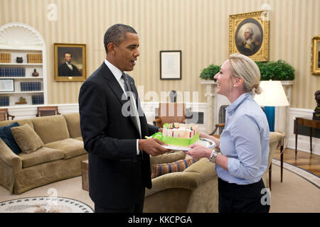 President Barack Obama presents a birthday cake to Personal Aide Anita Decker in the Oval Office, July 19, 2012. (Official White House Photo by Pete Souza)  This official White House photograph is being made available only for publication by news organizations and/or for personal use printing by the subject(s) of the photograph. The photograph may not be manipulated in any way and may not be used in commercial or political materials, advertisements, emails, products, promotions that in any way suggests approval or endorsement of the President, the First Family, or the White House. Stock Photo