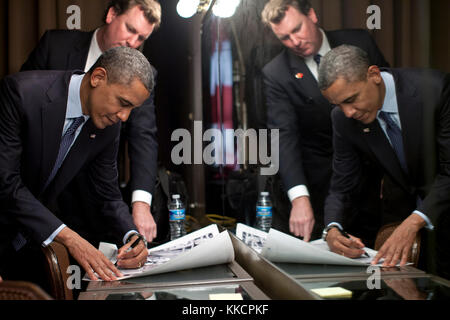 Trip Director Marvin Nicholson watches as President Barack Obama signs items after delivering remarks at the LGBT Leadership Council Gala in Beverly Hills, Calif., June 6, 2012. (Official White House Photo by Pete Souza)  This official White House photograph is being made available only for publication by news organizations and/or for personal use printing by the subject(s) of the photograph. The photograph may not be manipulated in any way and may not be used in commercial or political materials, advertisements, emails, products, promotions that in any way suggests approval or endorsement of  Stock Photo