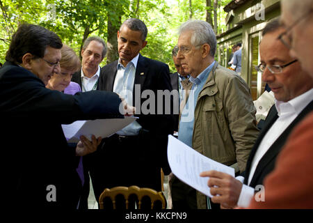 President Barack Obama talks with José Manuel Barroso, President of the European Commission, Chancellor Angela Merkel of Germany, Prime Minister Mario Monti of Italy, President François Hollande of France, and Herman Van Rompuy, President of the European Council, on the Laurel Cabin patio before the start of a G8 Summit working session at Camp David, Md., May 19, 2012. Mike Froman, Deputy NSA for International and Economic Affairs, listens in the background, third from left. (Official White House Photo by Pete Souza)  This official White House photograph is being made available only for public Stock Photo