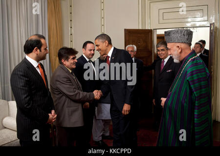 President Barack Obama greets members of the Afghan delegation as President Hamid Karzai watches at the Presidential Palace in Kabul, Afghanistan, May 1, 2012. (Official White House Photo by Pete Souza)  This official White House photograph is being made available only for publication by news organizations and/or for personal use printing by the subject(s) of the photograph. The photograph may not be manipulated in any way and may not be used in commercial or political materials, advertisements, emails, products, promotions that in any way suggests approval or endorsement of the President, the Stock Photo