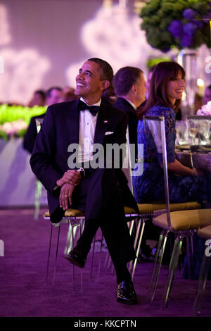 President Barack Obama listens as Prime Minister David Cameron of the United Kingdom offers a toast during the State Dinner on the South Lawn of the White House, March 14, 2012. Samantha Cameron is seated at right. Stock Photo