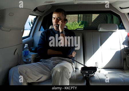 President Barack Obama talks on the phone with Afghanistan President Hamid Karzai from his vehicle outside the Jane E. Lawton Community Center in Chevy Chase, Maryland, Sunday, March 11, 2012. Stock Photo