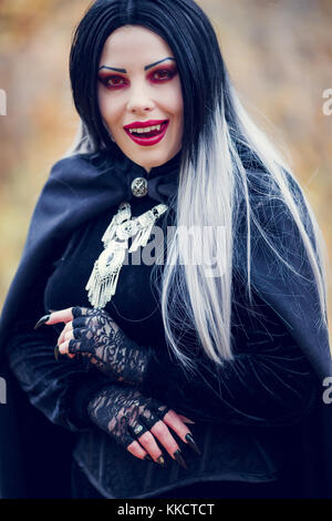 Photo of licking vampire woman with long hair, red eyes Stock Photo