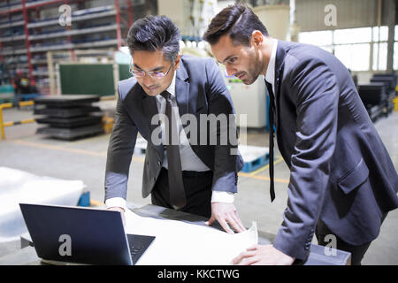 Businessman and engineer talking in the factory Stock Photo