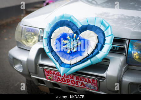 Wedding car with just married sign written on russian language and decorated heart on bumper. Stock Photo