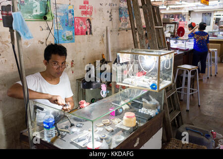 A jeweller at work in  Phsar Nath Market, Battambang, Cambodia Stock Photo