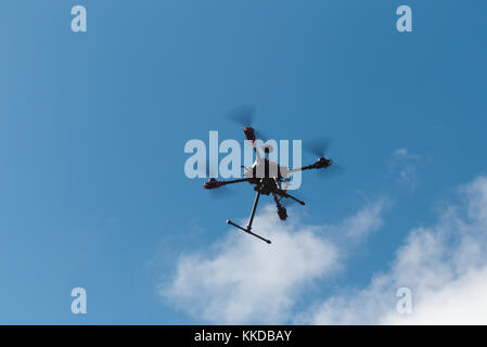 Aerial of custom built multirotor Quadcopter in flight against a blue sky Stock Photo