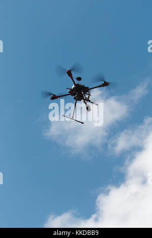 Aerial of custom built multirotor Quadcopter in flight against a blue sky Stock Photo