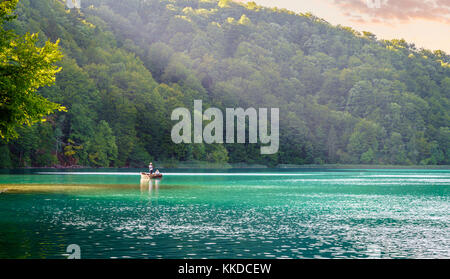 Plitvice Lakes National Park, Croatia - August 30, 2017: A couple is enjoying evening row boat ride on a lake in Plitvice Lakes National Park, Croatia Stock Photo