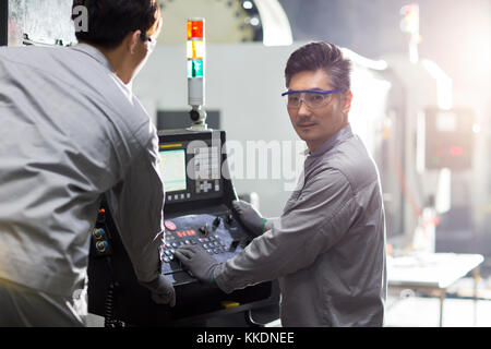 Confident Chinese engineers working in the factory Stock Photo