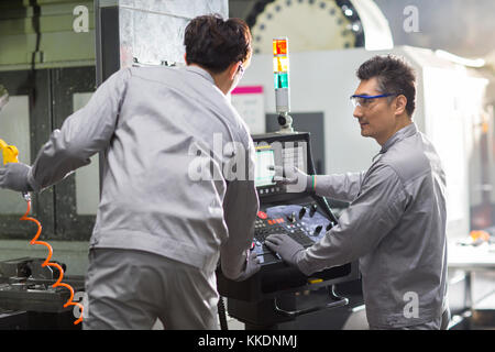 Confident Chinese engineers working in the factory Stock Photo