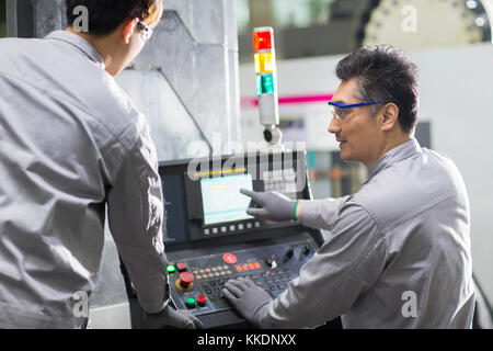 Confident Chinese engineers working in the factory Stock Photo