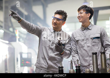 Confident Chinese engineers working in the factory Stock Photo