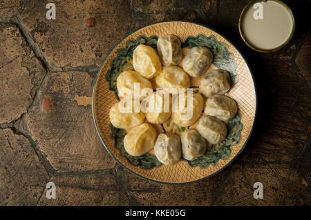 oriental dishes on decorative old tiles. meat in a test on a decorative old paving stone Stock Photo