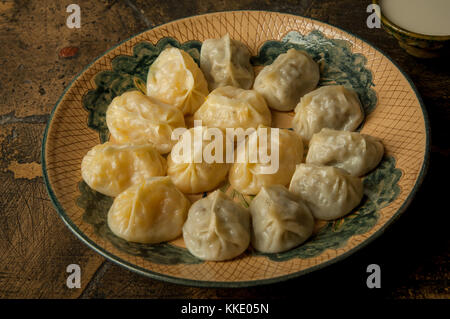 oriental dishes on decorative old tiles. meat in a test on a decorative old paving stone Stock Photo
