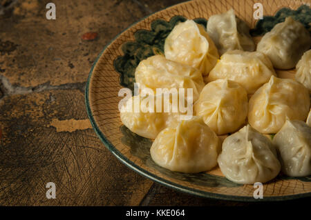 oriental dishes on decorative old tiles. meat in a test on a decorative old paving stone Stock Photo