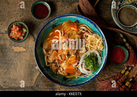 oriental dishes on decorative old tiles. noodles and spices with braid on decorative old paving stones Stock Photo