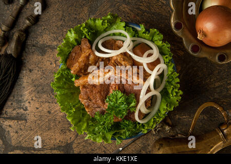 oriental dishes on decorative old tiles. fried meat and jug on decorative old paving stones Stock Photo