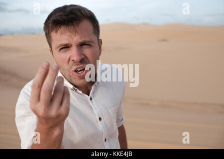 angry man shouting accusing someone standing in desert Stock Photo