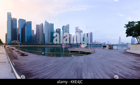 Singapore's Central Business District skyline at sunrise, with high rise buildings and waterfront, from Marina Bay terrace deck. Stock Photo