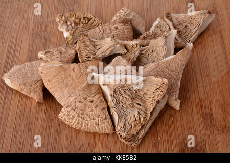 Dried pieces of Parasol mushroom on wooden bamboo chopping board, aromatic and tasty, ready for the kitchen Stock Photo