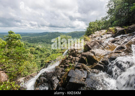 A rocky mountainside in the jungles of Belize with a stream splashing down the side of it.  A beautiful wilderness. Stock Photo