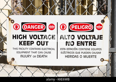 danger high voltage keep out sign on a chain link fence around electrical equipment Stock Photo