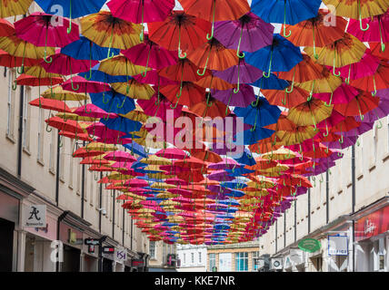 Open umbrellas hanging from wires above the shopping centre of the Southgate area of the city of Bath. Stock Photo