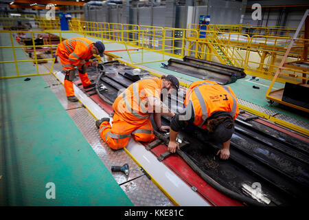 Alstom Class 390 Pendolino railway stock being refurbished at the start of the art Alstom Widnes repainting plant, workers working on the roof of the  Stock Photo