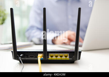 Man Using A Router Wireless router concept. Man using smartphone in background Stock Photo ...