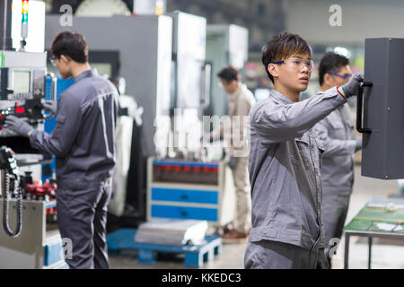 Confident Chinese engineers working in the factory Stock Photo