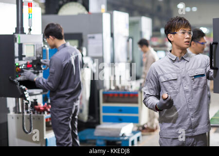 Confident Chinese engineers working in the factory Stock Photo