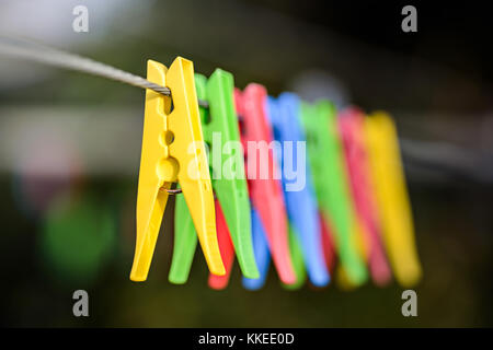 Colorful pegs hanging on clothesline Stock Photo