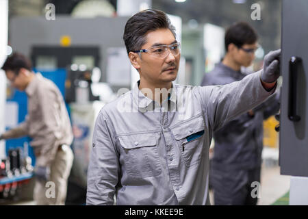 Confident Chinese engineers working in the factory Stock Photo