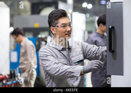 Confident Chinese engineers working in the factory Stock Photo